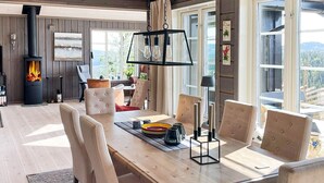 A modern dining area with a wooden table, cushioned chairs, and a central candle holder. - 10 Person Holiday Home in Nesbyen-by Traum (Nes)