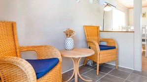 A room with two wicker chairs, a small round table, and a vase with dried flowers. - 5 Person Holiday Home in Karby (Øster Assels)