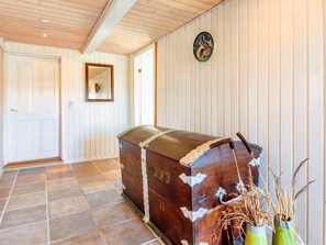 A wooden chest with metal hinges and a handle, placed against a wall with vertical paneling. - 5 Person Holiday Home in Karby (Øster Assels)