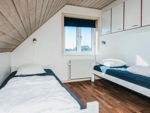 A bedroom with two beds, a window, and a radiator. - 12 Person Holiday Home in Thyboron (Thyborøn)