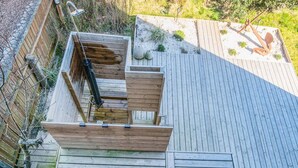A wooden deck with a built-in bench and a small garden area. - 12 Person Holiday Home in Thyboron (Thyborøn)