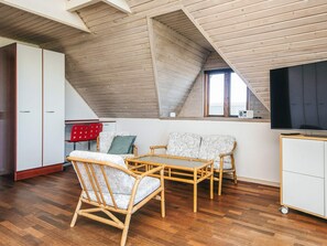 A loft-style room with high ceilings, wooden beams, a large window, and a television. - 12 Person Holiday Home in Thyboron (Thyborøn)