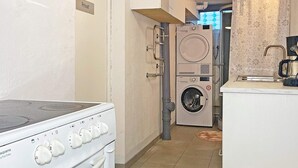 A kitchen with a stove, a washing machine, and a coffee machine. - 6 Person Holiday Home in Solvesborg (Sölvesborg)