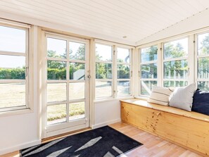 A room with large windows, a wooden bench, and a black rug. - 6 Person Holiday Home in Karrebaeksminde (Karrebæksminde)