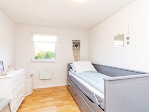 A bedroom with a bed, dresser, window, and wall-mounted mirror. - 6 Person Holiday Home in Karrebaeksminde (Karrebæksminde)
