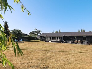 A building with a large open patio area, a covered seating area, and a barbecue setup. - 6 Person Holiday Home in Karrebaeksminde (Karrebæksminde)