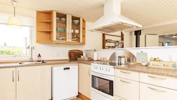 A kitchen with a dishwasher, stove, and wooden cabinets.
