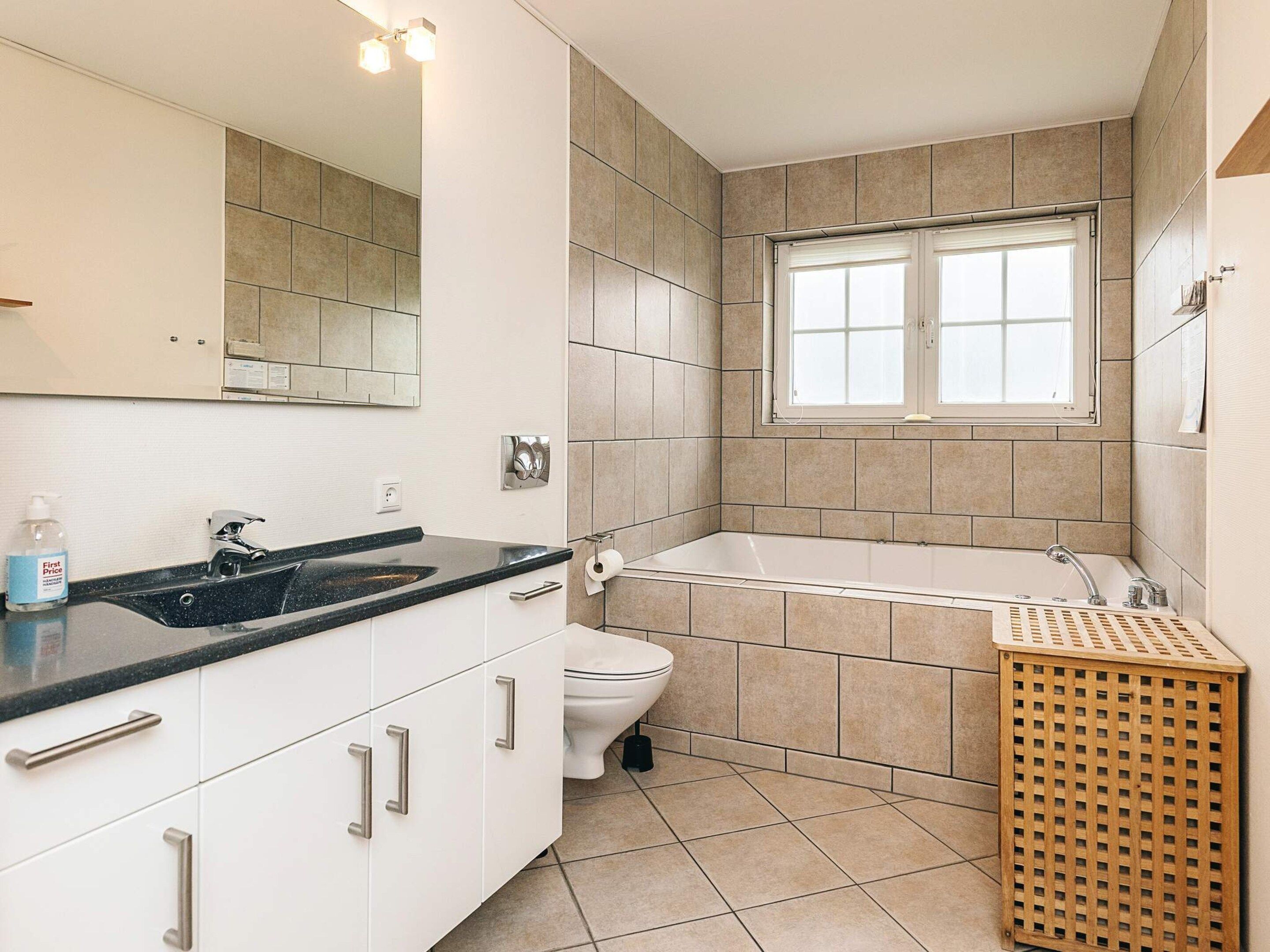A bathroom with a sink, toilet, and bathtub.