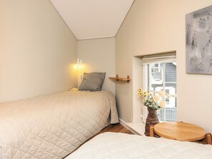 A bedroom with a bed, bedside table, and a window with a view. - 8 Person Holiday Home in Bogense (Bogense)