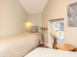 A bedroom with a bed, bedside table, and a window with a view.
