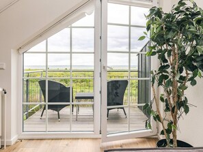 A room with a sliding glass door leading to an outdoor deck with two chairs and a table. - 8 Person Holiday Home in Bogense (Bogense)