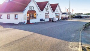 A white building with a red roof, labeled "BOTIK" and "HAVEN'S ROGERI CAFE". - 6 Person Holiday Home in Farso (Farso)