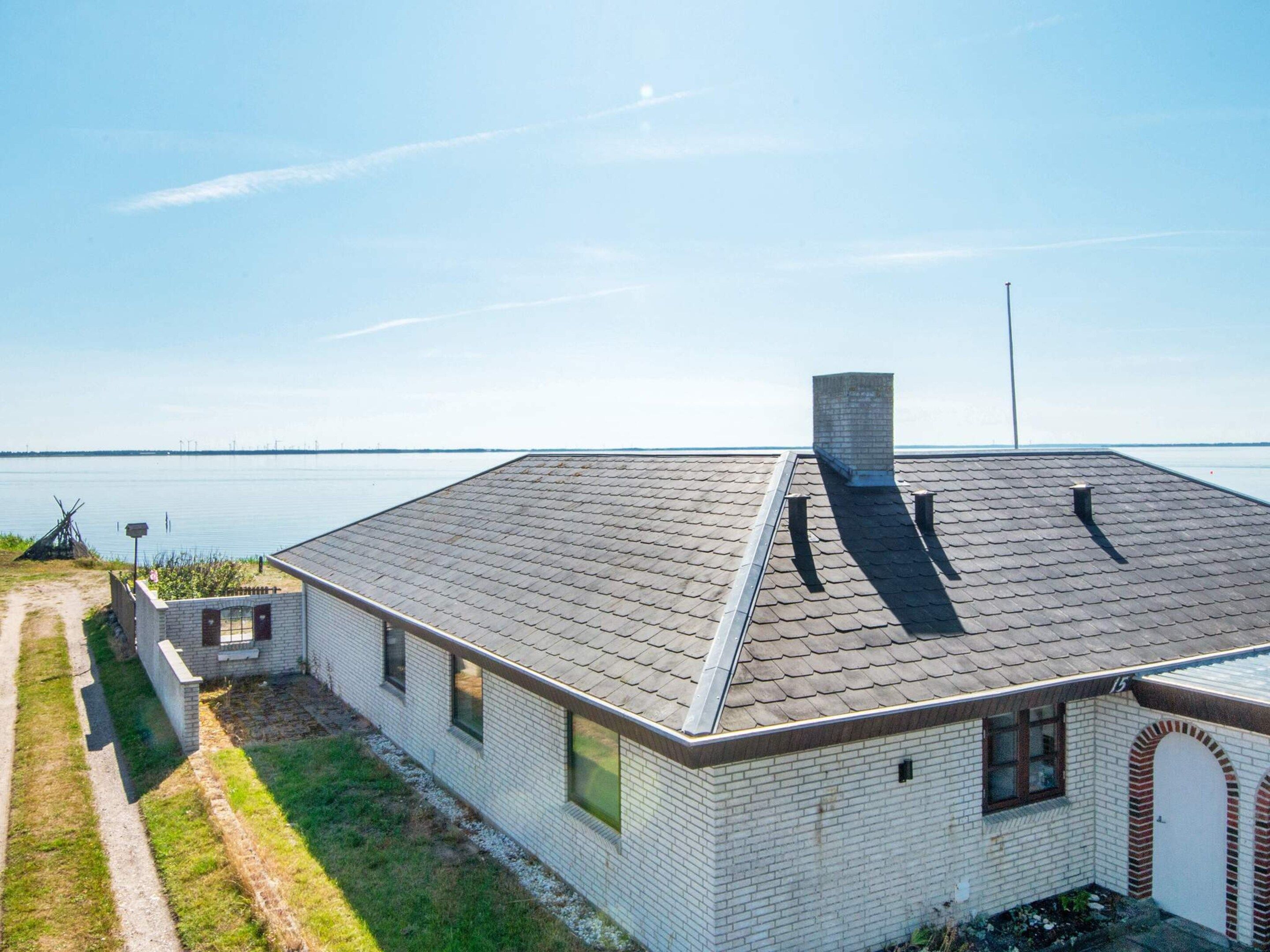 A single-story house with a sloped roof, a chimney, and a small attached garage.