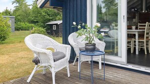 A deck with wicker chairs and a table, a potted plant, and a sliding glass door leading to an indoor area. - 6 Person Holiday Home in Vaeggerlose (Vaeggerlose)