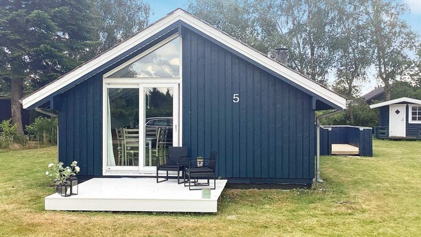 A small, dark blue building with a large glass door and a number '5' on the side. - 6 Person Holiday Home in Vaeggerlose (Vaeggerlose)