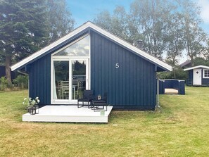A small, dark blue building with a large glass door and a number '5' on the side. - 6 Person Holiday Home in Vaeggerlose (Vaeggerlose)