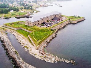 A large stone building with a flat roof, surrounded by a fortified wall and a moat. - 4 Person Holiday Home in Drottningskar (Drottningskär)
