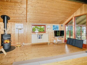 A wooden interior with a fireplace, a television, and a sofa. - 5 Person Holiday Home in Jaegerspris (Jægerspris)