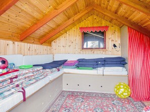 A cozy attic room with a loft bed, a small window, and a red curtain. - 5 Person Holiday Home in Jaegerspris (Jægerspris)