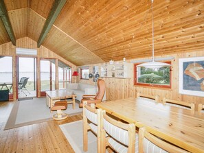 A wooden interior with a dining area, sofa, and a view of the outdoors. - 5 Person Holiday Home in Jaegerspris (Jægerspris)