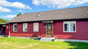 A red single-story house with a tiled roof, a front door with a number '23', and a small porch area. - 4 Star Holiday Home in Dio (Diö)