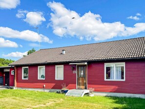 A red single-story house with a tiled roof, a front door with a number '23', and a small porch area. - 4 Star Holiday Home in Dio (Diö)