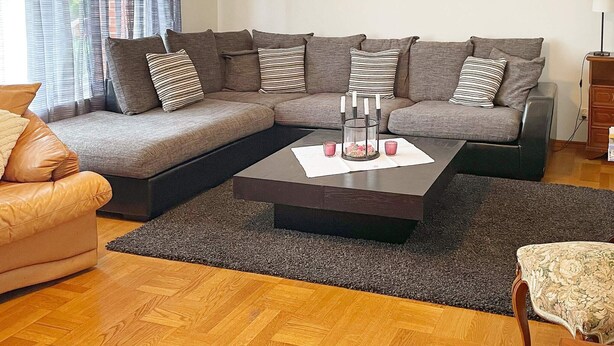 A living room with a sectional sofa, a coffee table, and a patterned rug. - 4 Star Holiday Home in Dio (Diö)
