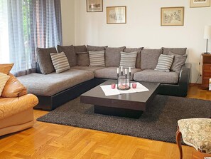 A living room with a sectional sofa, a coffee table, and a patterned rug. - 4 Star Holiday Home in Dio (Diö)