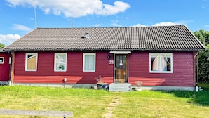 A red single-story house with a tiled roof, a front door, and two windows. - 4 Star Holiday Home in Dio (Diö)