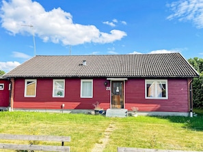A red single-story house with a tiled roof, a front door, and two windows. - 4 Star Holiday Home in Dio (Diö)