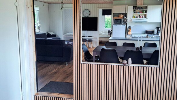 A compact living space with a dining area, kitchenette, and a sofa in the living room. - 6 Person Holiday Home in Hadsund (Hadsund)
