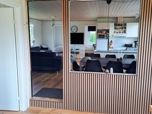A compact living space with a dining area, kitchenette, and a sofa in the living room. - 6 Person Holiday Home in Hadsund (Hadsund)