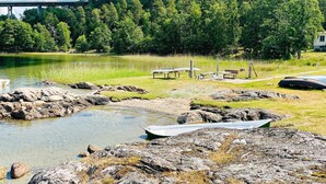 A lakeside view with boats, a picnic area, and a bridge in the background. - 6 Person Holiday Home in Henan (Henån)