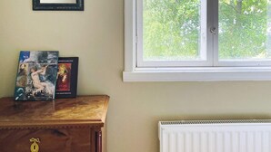 A room with a wooden dresser, two books, a mirror, and a window with a view of trees. - 6 Person Holiday Home in Henan (Henån)