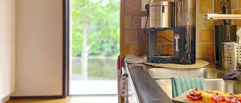 A modern kitchen with a coffee maker, a toaster, and a stainless steel sink.