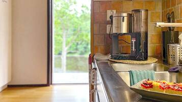 A modern kitchen with a coffee maker, a toaster, and a stainless steel sink.