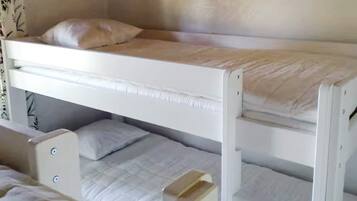 A bunk bed with two levels, each with a pillow and a mattress.