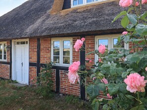 A traditional brick house with a thatched roof, white-framed windows, and a door. - 6 Person Holiday Home in Guldborg (Guldborg)