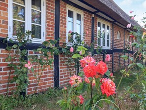 A brick building with a thatched roof and white-framed windows. - 6 Person Holiday Home in Guldborg (Guldborg)