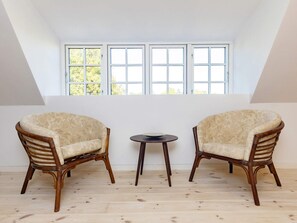 A room with two upholstered chairs, a small round table, and a large window with multiple panes. - 6 Person Holiday Home in Guldborg (Guldborg)