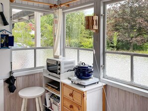 A compact kitchen with a built-in microwave, a slow cooker, and a small stool. - 4 Person Holiday Home in Kolmarden (Kolmården)