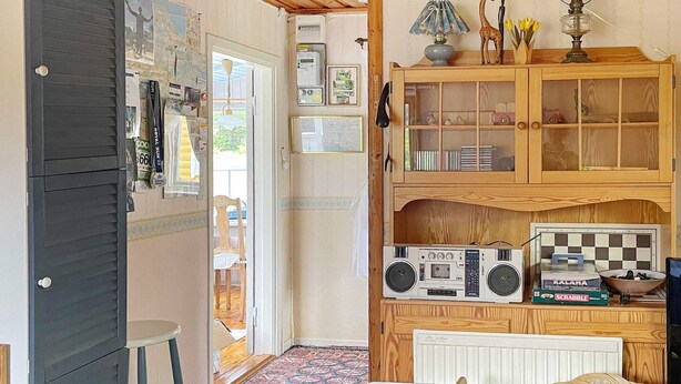 A kitchen with a wooden cabinet, a radio, and a Scrabble game. - 4 Person Holiday Home in Kolmarden (Kolmården)