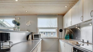 A compact kitchen with a microwave, kettle, and stainless steel appliances. - 6 Person Holiday Home in Hemmet (Hemmet)