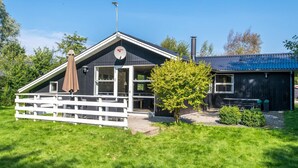 A two-story building with a white fence, a tree, and a bench. - 6 Person Holiday Home in Hemmet (Hemmet)