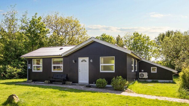 A single-story building with a dark exterior, a white door, and a number '6' on the front. - 6 Person Holiday Home in Hemmet (Hemmet)