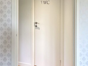 Une porte fermée, dotée d’une serrure et d’un trou de serrure, et portant l’inscription « WC » pour indiquer qu’il s’agit de toilettes.