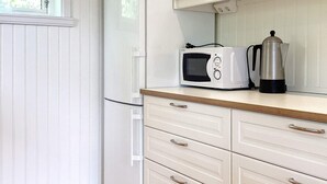 Une cuisine équipée d’un four à micro-ondes, d’une machine à café et d’un plan de travail en bois.