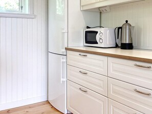 A kitchen with a microwave, a coffee maker, and a wooden countertop. - 4 Person Holiday Home in Uddevalla (Uddevalla)