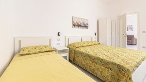 Ein Schlafzimmer mit zwei Betten, einem weißen Schrank, einem Nachttisch und einem Bild an der Wand.