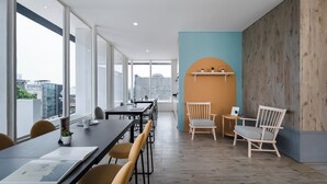 A modern office space with large windows, a long table, and several chairs. - Cove Art Living (Jakarta)